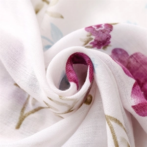 Macro shot of cotton linen fabric with purple floral prints and detailed weave texture