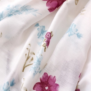 Detailed close-up of cotton linen scarf with purple and blue floral prints and soft texture