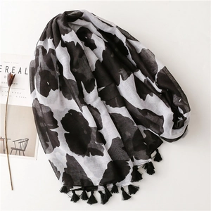 Detail of black and white floral scarf featuring fringe edges and lightweight texture