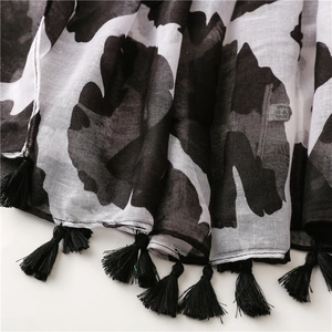 Detail of floral print scarf fabric texture with handmade black tassel fringe edge