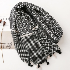 Close-up of lightweight black and white floral scarf with decorative fringe tassels