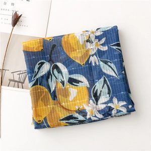 Detail of navy cotton linen scarf with yellow lemon print and delicate fringe edges