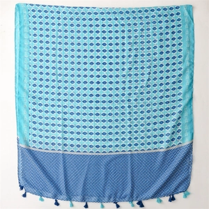 Detail of blue floral cotton scarf with tassel fringe and geometric patterns