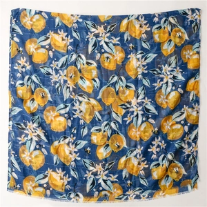 Detail of lemon and floral print on navy linen scarf with fine tassel edges