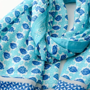 Detailed view of lightweight floral scarf with navy blue roses and soft tassel edges