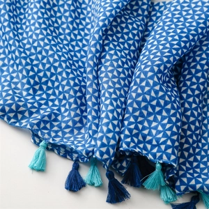 Detail of blue and white geometric triangle scarf with decorative handmade tassels