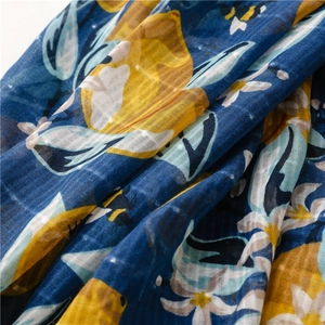 Close-up of lightweight navy cotton linen scarf with bright yellow lemon and flower prints