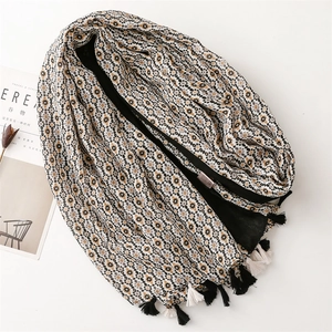 Detail of floral linen-feel scarf featuring intricate tassels and geometric patterns