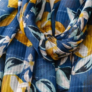 Detailed texture of lightweight cotton linen scarf with lemon and floral print patterns