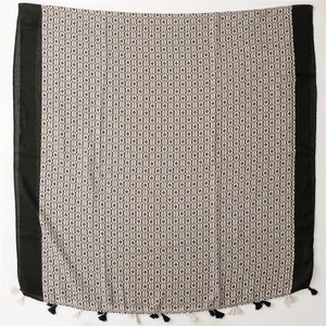 Detailed flat lay of geometric star pattern scarf with bohemian tassels and black border