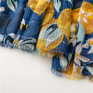 Detailed close-up of floral and bee printed scarf with fine tassel edge craftsmanship