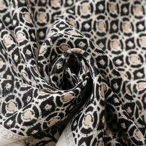 Detail eines weichen Schals mit Leinen-Haptik und schwarzen beige geometrischen Mustern
