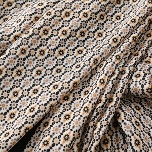 Detail of bohemian geometric print scarf fabric with soft drape and mustard yellow pattern