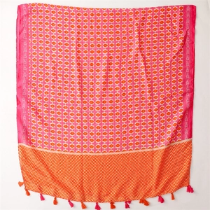 Detailed close-up of geometric floral prints and fringe tassels on a soft cotton scarf