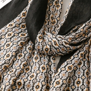 Detailed macro view of bohemian geometric floral patterns on soft cotton-linen scarf fabric