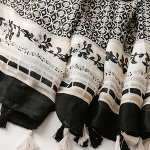 Detail eines weichen Leinen-Gefühl-Schals mit ethnischen Mustern und eleganten Quasten