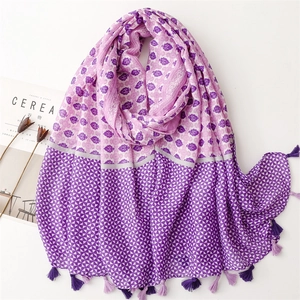 Macro detail of purple floral cotton scarf with geometric patterns and fringe tassels