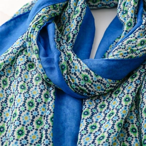 Close-up of lightweight cotton linen scarf featuring blue solid and floral patchwork