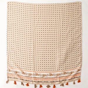 Detail eines beige Baumwoll-Leinen-Schals mit braunen Punkten und Fransenquasten
