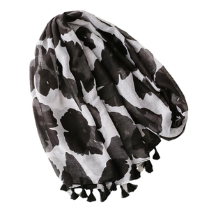 Lightweight black and white floral scarf with tassel fringe on a plain white background