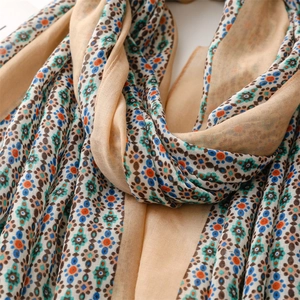 Detail view of cotton-linen scarf fabric with ethnic floral patterns and soft texture