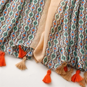 Close-up of Bohemian floral print on linen-feel scarf with delicate colorful tassels