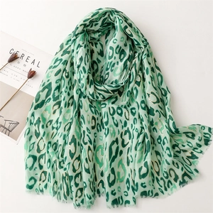 Detail of green leopard print scarf with gold foil accents and natural frayed edges