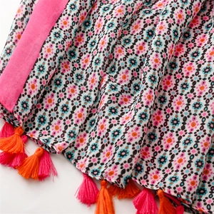 Detail of bohemian floral cotton scarf featuring colorful tassels and woven texture