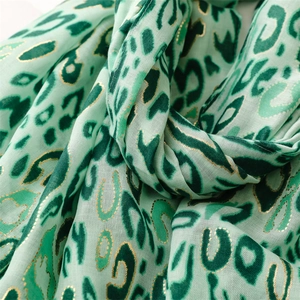 Detail of light green leopard print scarf with fine gold foil and soft fabric texture