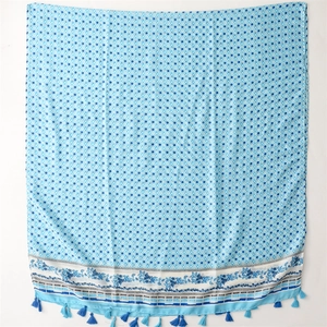 Detailaufnahme des blauen Polka-Dot-Schals mit Blumendruck und weichen Fransenquasten