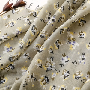 Close-up of sage green floral scarf showing fine cotton linen weave and artistic prints