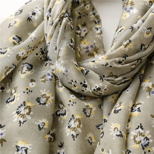 Detail of soft sage green floral scarf with delicate texture and elegant drape