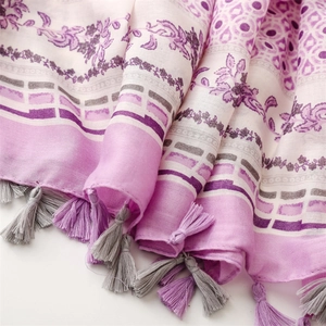 Detail eines lila Schals mit Blumenmuster, geometrischen Prints und weichen Fransen