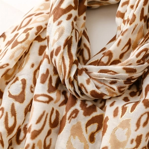 Detail shot of leopard print scarf featuring elegant gold foil accents and soft raw edges