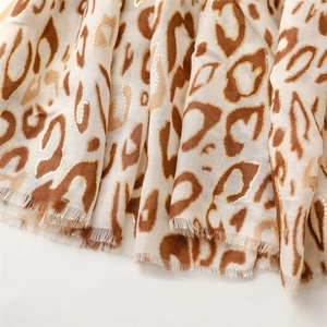 Detail of leopard print scarf with gold foil accents and soft fringed edges
