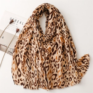 Elegant leopard print scarf with gold foil accents and soft frayed edges on white background