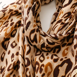 Detail of soft leopard print scarf featuring elegant gold foil accents and frayed edges