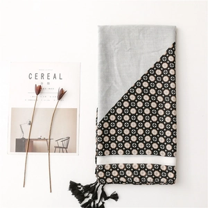 Blue geometric print scarf with cotton linen texture and tassels on white background