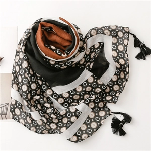Detail of blue geometric print scarf with soft texture and black tassel fringe edges