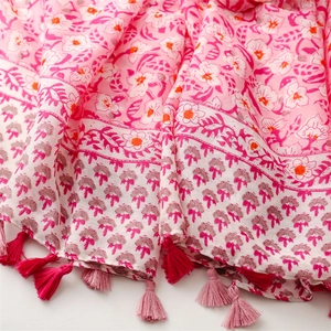 Detail of pink floral print scarf with soft cotton-linen texture and fringed edges