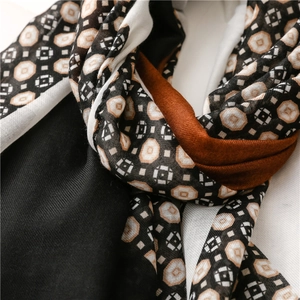 Detailed close-up of geometric pattern and orange-black color block on cotton-linen scarf