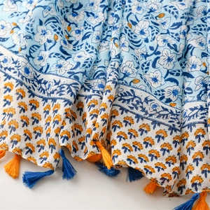 Detail of floral printed scarf showing soft linen texture and elegant fringe tassels