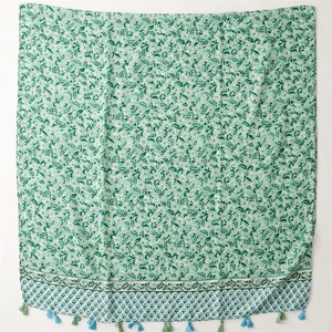 Detail of light green floral scarf featuring soft cotton-linen feel and colorful fringe