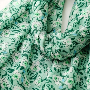 Detail of floral printed linen-feel scarf with delicate tassels and soft texture