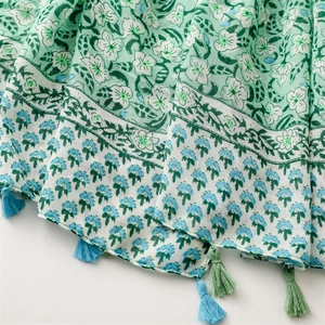 Detail of light green floral scarf featuring soft fringe and elegant bohemian pattern