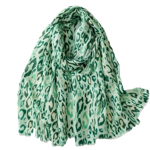 Light green leopard print scarf with gold accents and soft frayed edges on white background