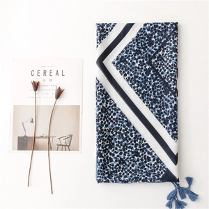 Blue geometric leopard print scarf with tassels and navy polka dots on white background
