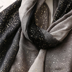 Detailed view of black and grey gradient scarf with golden metallic foil specks