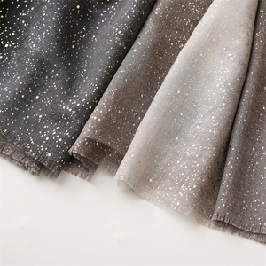Close-up of lightweight linen-feel scarf fabric with gold foil and frayed edges