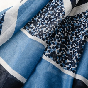 Close-up of geometric leopard print scarf fabric with blue and white weave texture